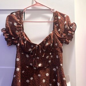 B. Smart brown dress with white flowers. Is a 7 in women’s and is polyester.